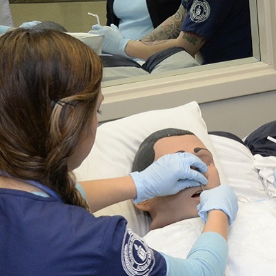 A student nurse working with a simulated patient.